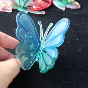 Resin butterfly detail view, blue gradient transparent design with gold foil flakes inside.