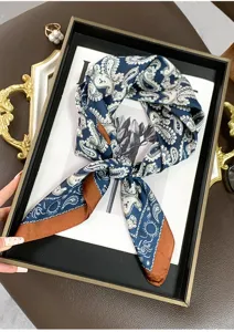 Vue détaillée d'un petit foulard en soie bleu marine avec motif cachemire et bord marron