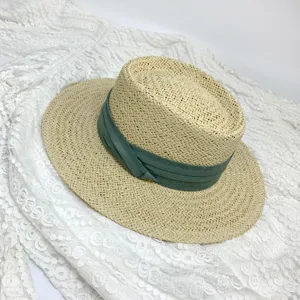 Details of a classic women's flat top straw hat with a stylish green ribbon, summer sun hat.