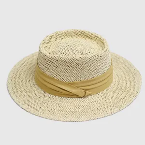 Close-up detail view of the handmade straw hat weave texture and khaki ribbon accent.