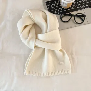 Close-up detail of cozy solid color knit winter scarf, soft texture, elegant daily winter wear.