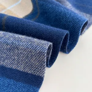 Close-up detail shot of a soft blue and grey plaid winter scarf texture and folded fabric.