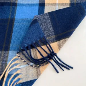 Detailed view of women's winter blue and beige plaid scarf showing soft fabric and fringe texture.