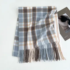 Detailed view of the cozy blue and white plaid winter scarf with elegant fringe trim.
