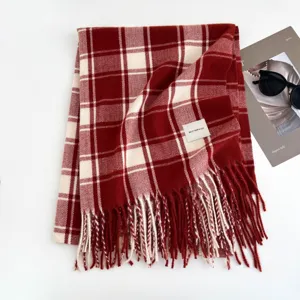 Cozy red and white plaid winter scarf with elegant fringe detail and soft woven texture.