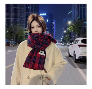 Detail view of a cozy winter plaid scarf worn outdoors, featuring a soft texture and pattern.
