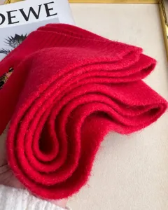 Red knit wool scarf with cute bear embroidery detail, warm winter fashion accessory.