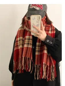 Detail view of the cozy red plaid winter scarf showing soft knit texture and stylish fringe design.