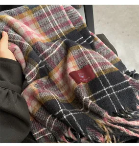 Close-up of cozy multi-color plaid winter scarf detail, soft cashmere-feel fabric texture.