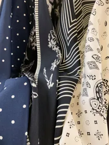 Close-up detail of vintage style silk scarves featuring chic polka dot, stripe and paisley patterns.