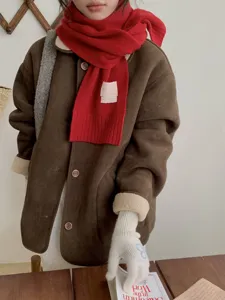 Écharpe tricotée rouge d'hiver confortable associée à une veste en daim marron élégante et chaude.