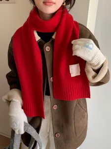 Vue détaillée de l'écharpe en tricot rouge d'hiver et de gants assortis confortables.