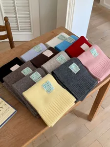 Écharpe d'hiver en laine tricotée multicolore et douillette avec écusson de marque chic.