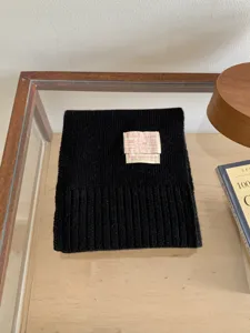 Écharpe en tricot noir pour l'hiver, douce et chaude, texture confortable et style casual chic.