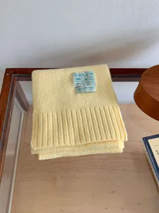 Écharpe d'hiver tricotée jaune confortable avec étiquette, douce et chaude pour la saison.