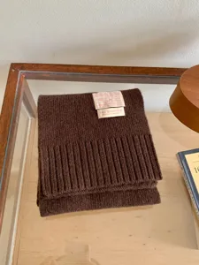 Gros plan détaillé d'un écharpe en tricot marron foncé confortable avec texture côtelée.