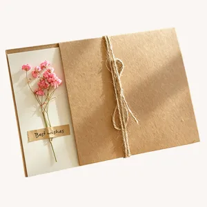 Handmade retro kraft greeting card detail with pink dried gypsophila and twine wrap.