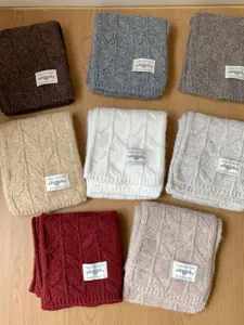 Detailed view of chunky knit winter scarf with classic cable pattern, cozy and warm texture.