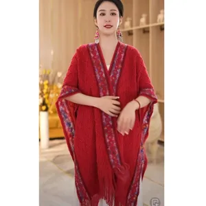Details of the red knitted ethnic style women's shawl, featuring tassels and patterns.