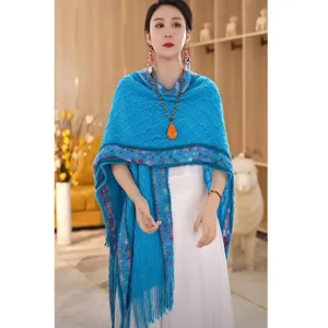 Blue knitted shawl for women, ethnic style cape wrap with tassel hem, elegant travel accessory.