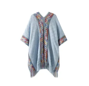Light blue knitted poncho cape with colorful ethnic pattern trim and fringe hem for women.