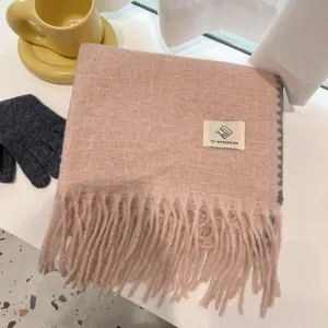 Women winter thick warm pink plaid woven scarf with fringe and brand label on display.