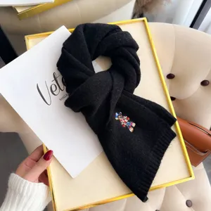Black knitted wool scarf featuring cute embroidered bear design, perfect winter cozy accessory.