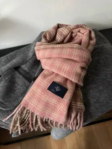Vue détaillée de l'écharpe d'hiver à carreaux rose et marron avec franges et étiquette.