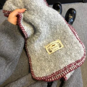Cozy gray winter knit scarf with wine red edge stitch and stylish detail label for women.