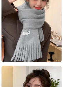 Grey knitted tassel scarf detail view, cozy winter neckwear accessory close up display.