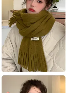 Olive green knitted fringed scarf detail, soft warm winter neck accessory worn by model.