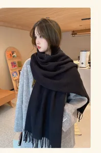 Detailed view of the winter warm knitted scarf in cozy indoor styling with soft texture.