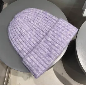 Soft purple knitted beanie cap close up detail showing cozy texture and ribbed knit design.