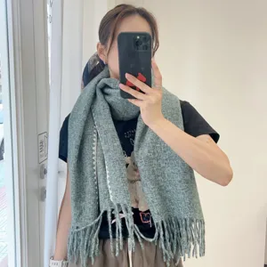 Detailed view of the cozy winter green knitted scarf with stylish tassels and warm texture.
