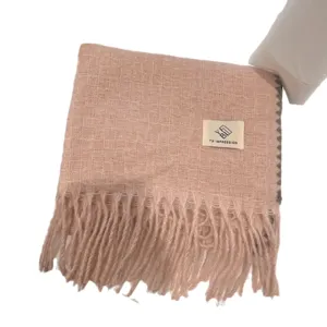 Pink winter thick warm plaid scarf for women with elegant tassels and soft knitted texture.