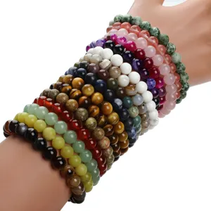 Close-up detail of colorful gemstone beaded bracelets stacked on display, vibrant crystal stones.