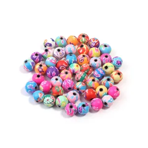 Vue détaillée de perles rondes en argile polymère imprimées colorées, parfaites pour les bijoux DIY.