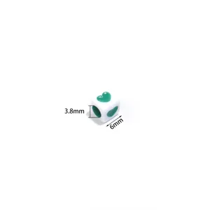 Close-up detail of acrylic square heart bead, white with green heart pattern, 3.8mm and 6mm.