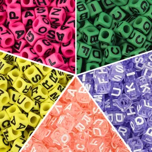 Gros plan détaillé de perles de lettres carrées en acrylique coloré avec des impressions.