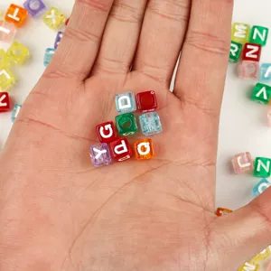Vue détaillée des perles de lettres carrées en acrylique aux couleurs vives et claires.