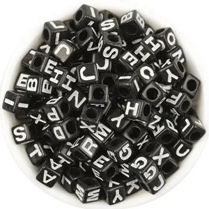 Perles alphabet en acrylique noir avec lettres blanches pour la création de bijoux.