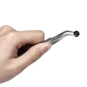 Primer plano de unas pinzas de precisión curvadas de acero inoxidable que agarran una cuenta negra.