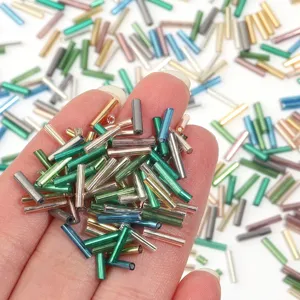 Gros plan de perles tubulaires en verre aux couleurs vibrantes pour accessoires de bijoux DIY.