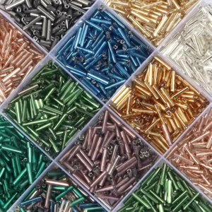 Perles de verre tubulaires assorties dans une boîte pour fabrication de bijoux et bracelets.