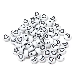 Detail view of white acrylic beads featuring assorted black heart star and flower patterns
