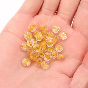 Close-up detail of transparent acrylic beads with gold star heart patterns on hand.