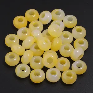Close-up detail of yellow acrylic abacus spacer beads, glossy semi-transparent DIY jewelry.