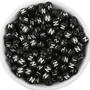 Close-up detail of black acrylic letter N beads, round loose beads for DIY jewelry making.