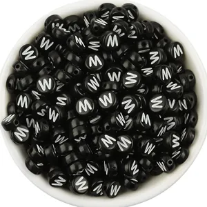 Detailed close up of black acrylic round alphabet letter beads with white print for DIY jewelry.