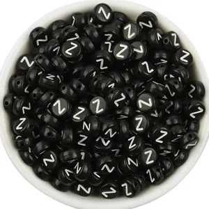 Detailed shot of black acrylic flat round letter beads with white letter Z for DIY bracelets.